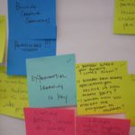 Post-its on a wall: "Experiential learning is key" written on one.
