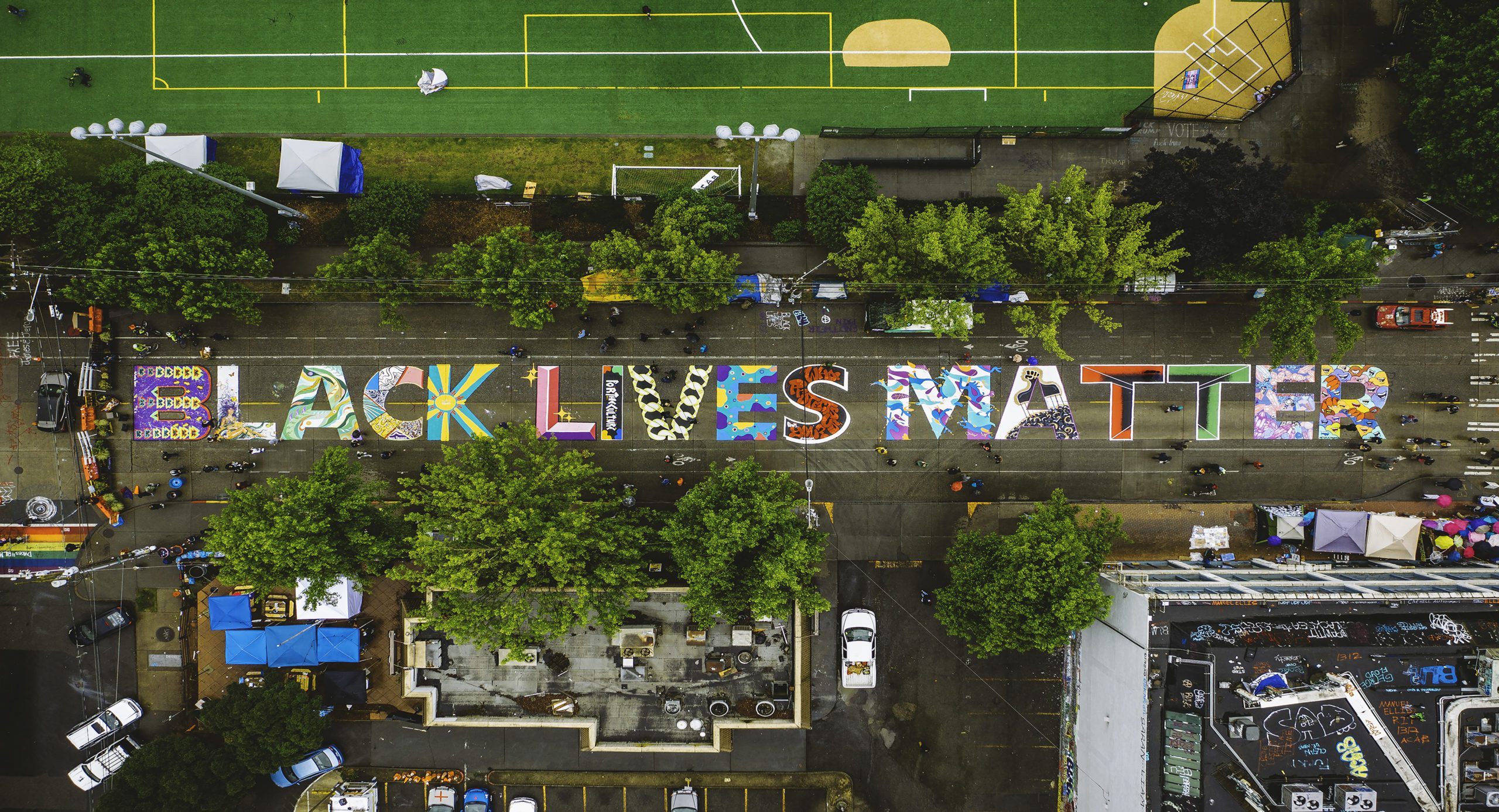 Drone shot of the Black Lives Matter mural on the street rendered in colorful block letters.