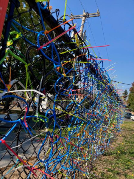 Colorful zip ties on a chain link fence