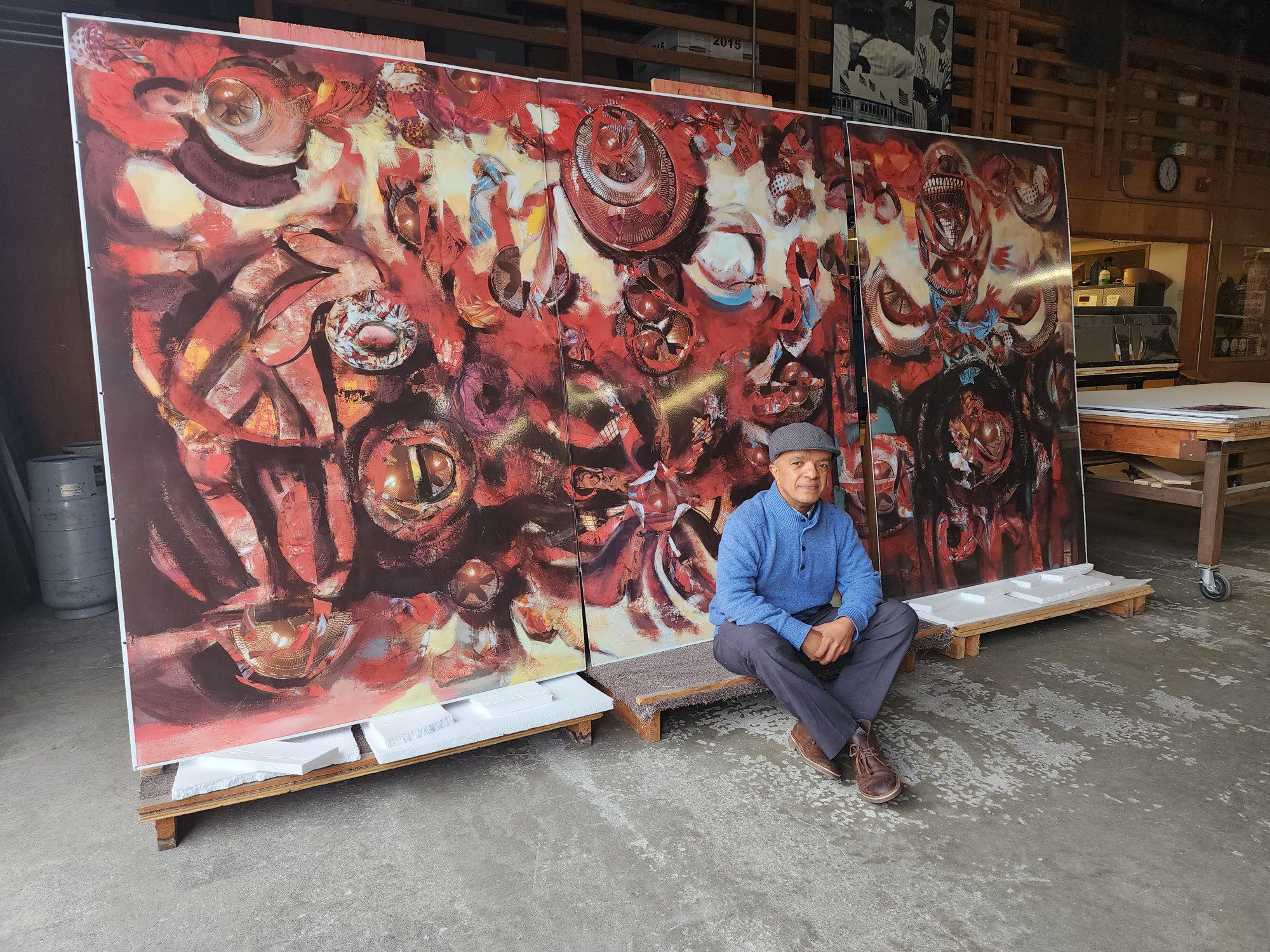 Man sits in front of large red abstract painting