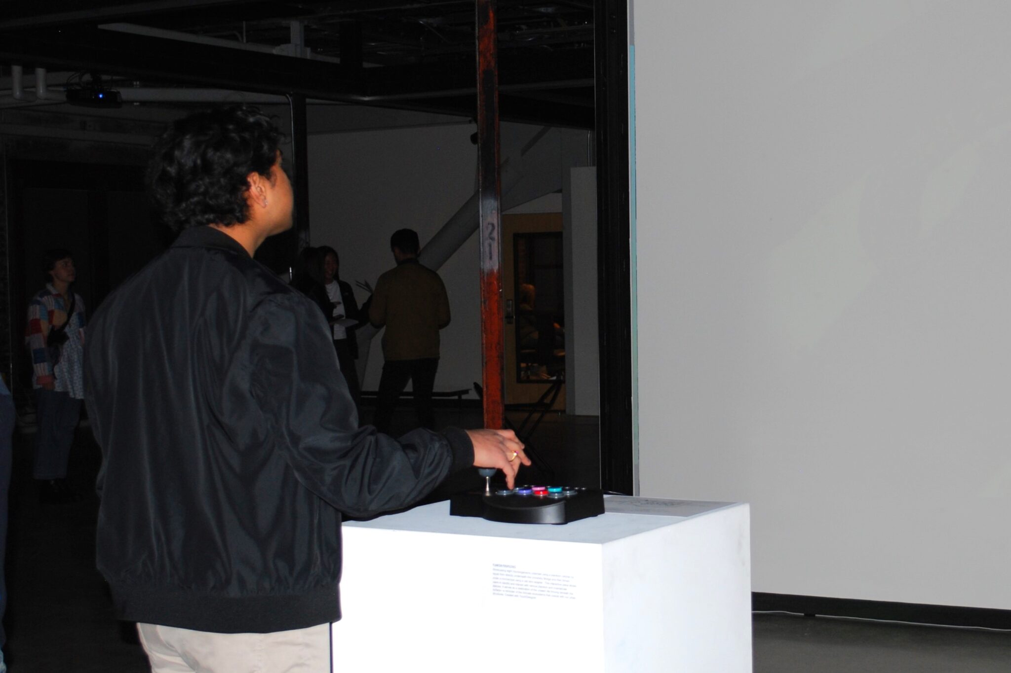 person using a joystick on a pedestal to control projected video
