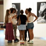 group of young adults talk in the gallery