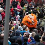 A crowd at the Lunar New Year festival with an orange dragon