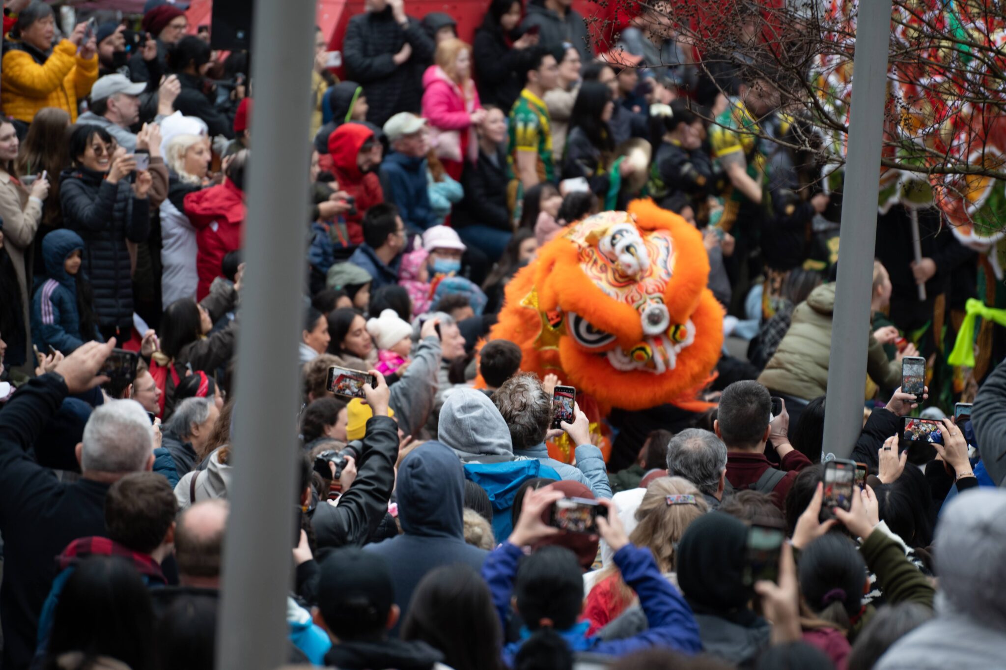 A crowd at the Lunar New Year festival with an orange dragon