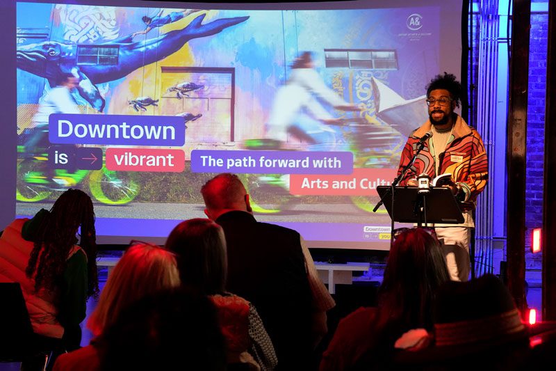 Quenton reads in front a full audience.