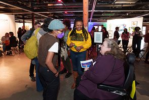 A guest in a wheelchair chats with two others