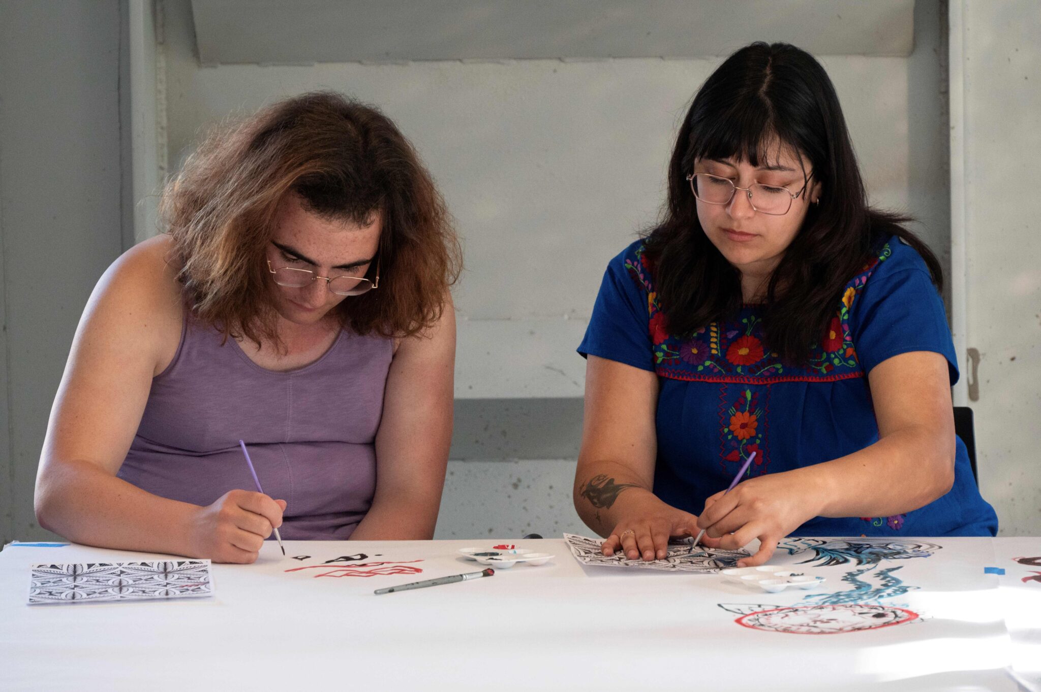 two people focused on painting