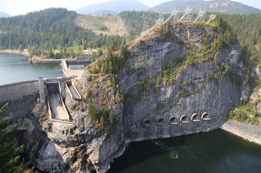 Stunning juxtaposition of man-made and natural structures: a dam is built into a large cliff face, the water level hundreds of feet apart on each side.