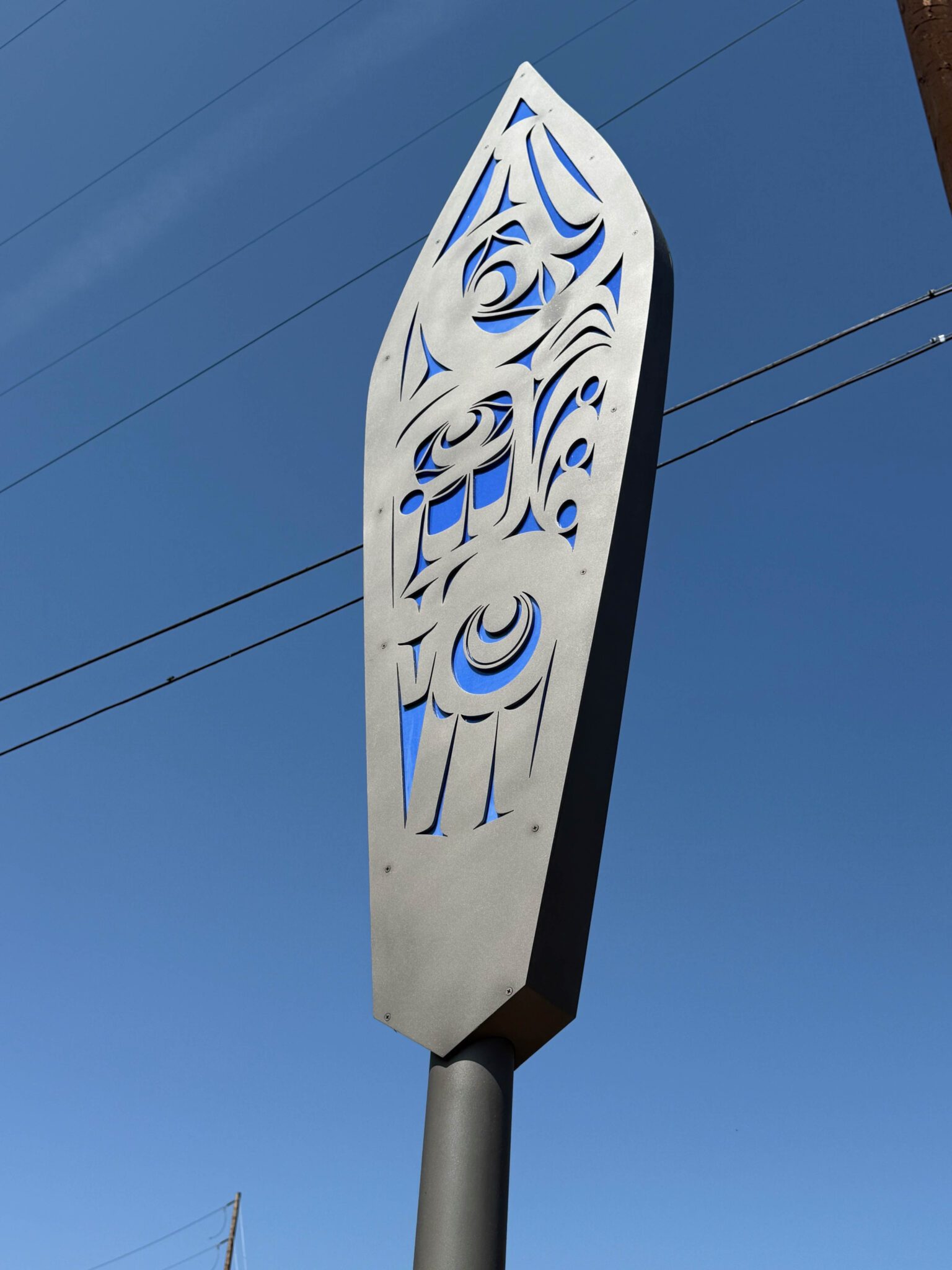 Close-up of one of the canoe paddles with blue coloring against a clear, blue sky.