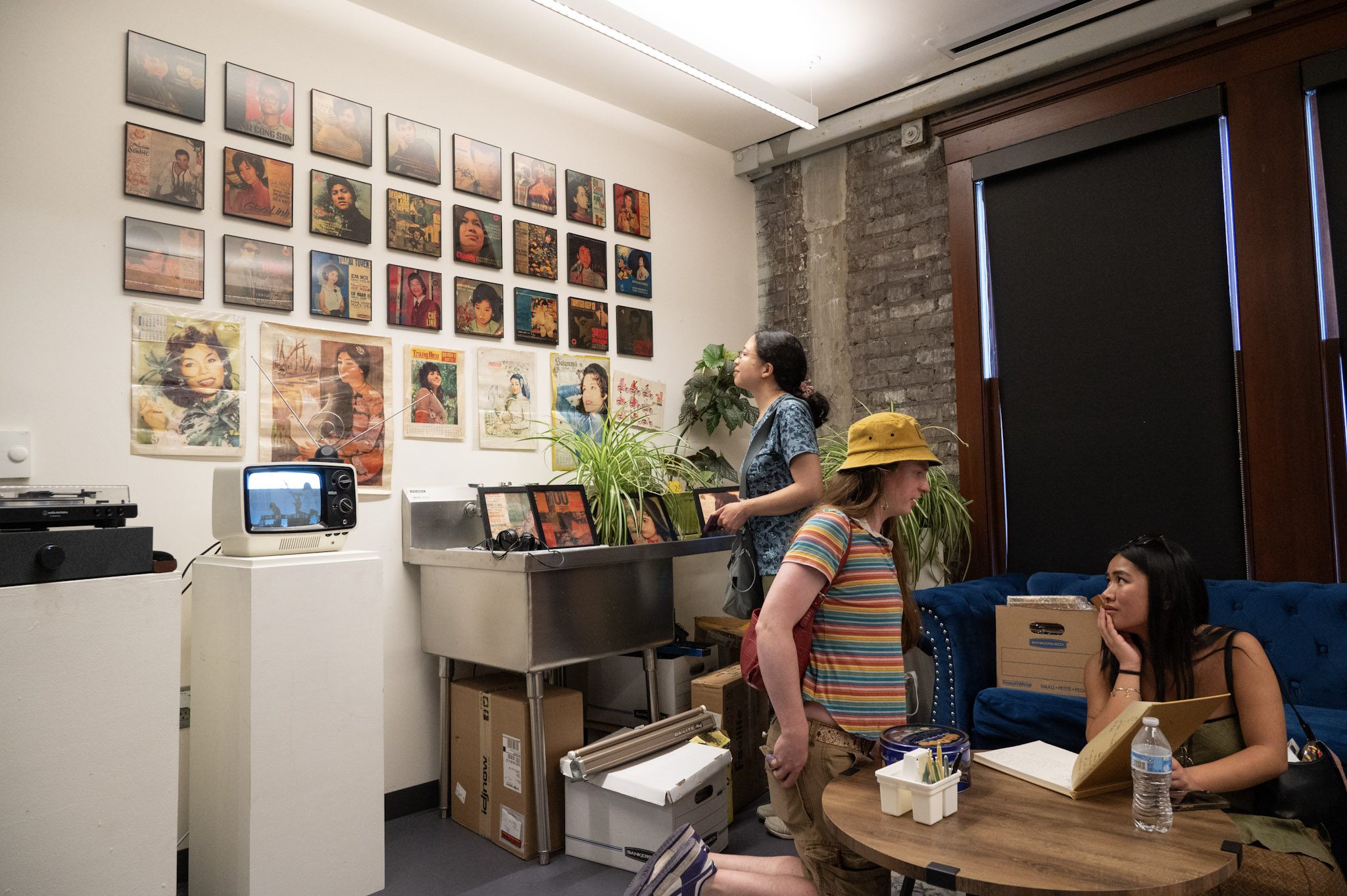 People peruse album covers in Thanh Tân's "South Vietnam’s Golden Music Archive" listening room.