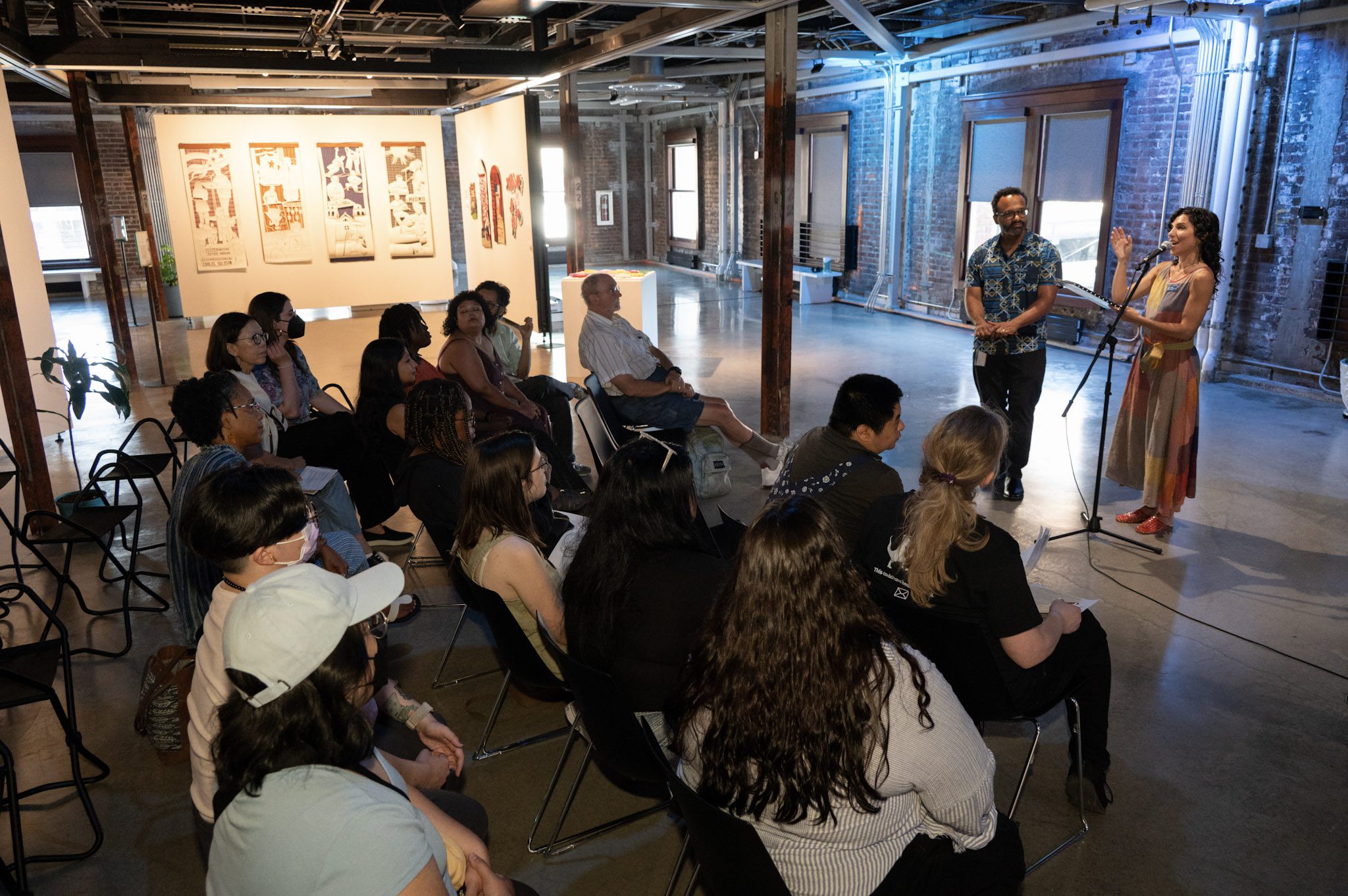 ARTS staff addresses a seated crowd of people.