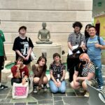 a group of teens and their teacher with a Buddha statue