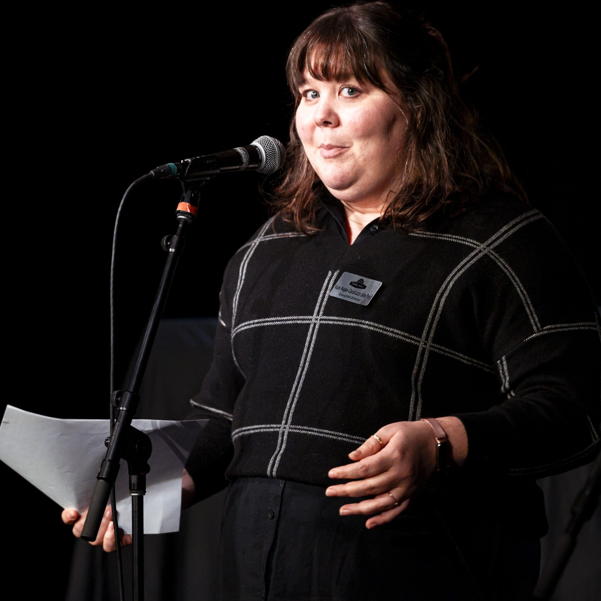A woman speaks at a microphone