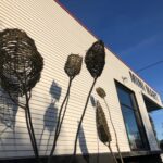 tall sculpture made of willow branches against the wall of Mini Mart City Park