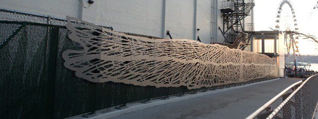 A large wooden cutout along a metal fence