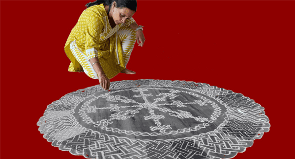 A woman draws an intricate design on the floor