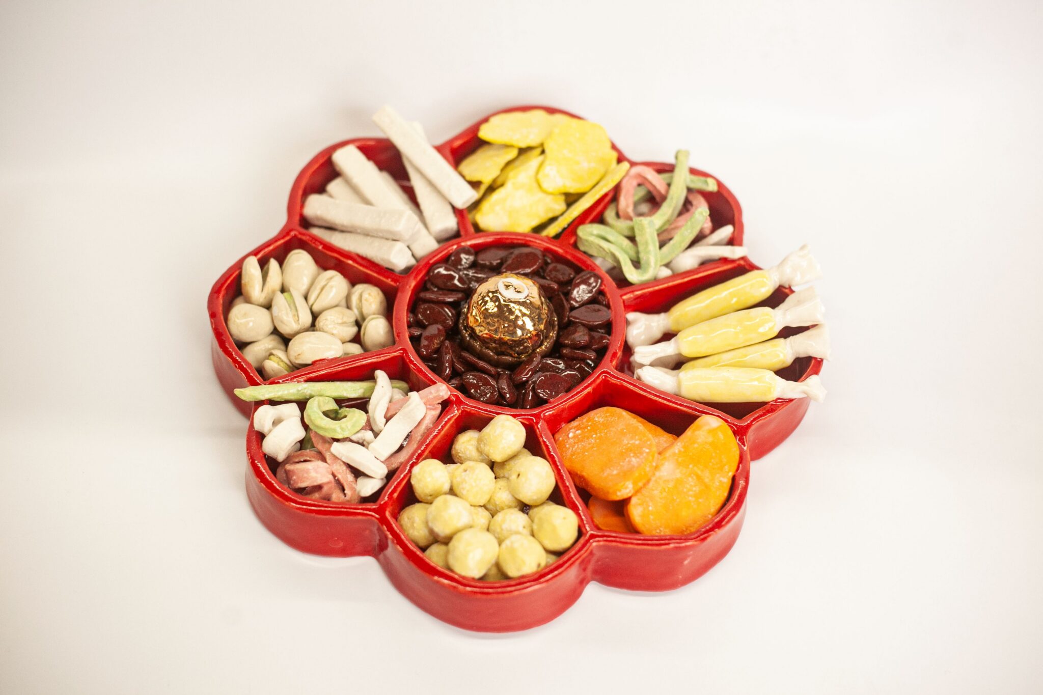 Realistic ceramic sculpture of holiday candy tray with different sweet treats