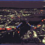 Video still of an animated lit up city at night from a bird-eye view