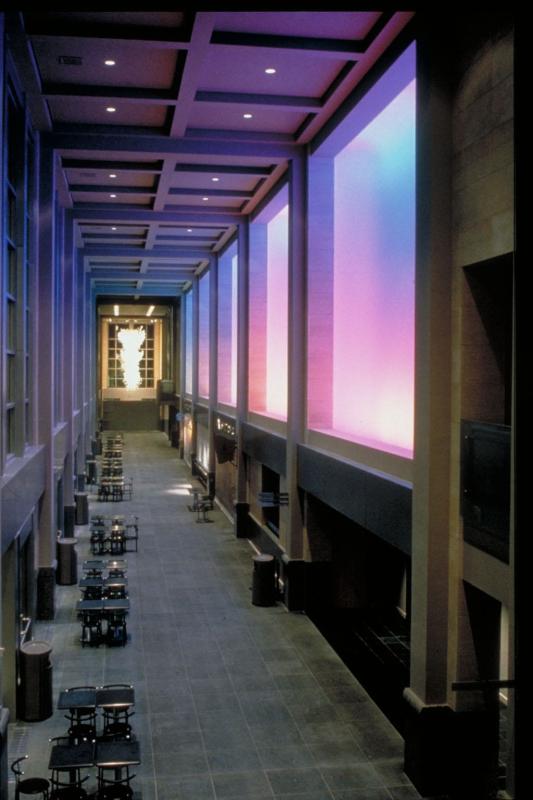 The interior of a large atrium at Benaroya Hall bathed in purple light.