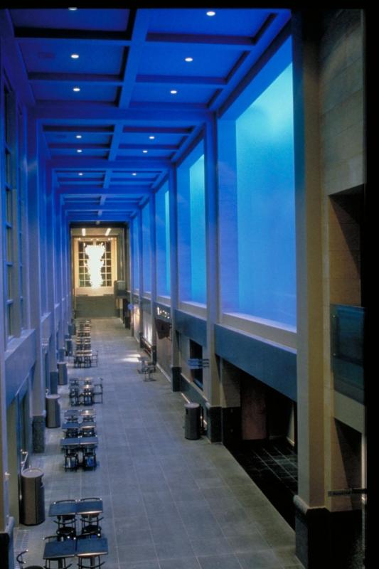 The interior of a large atrium at Benaroya Hall bathed in blue light.