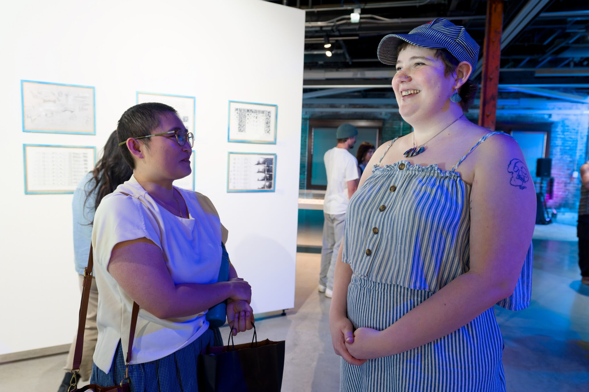Two people having a discussion with artwork in the background.