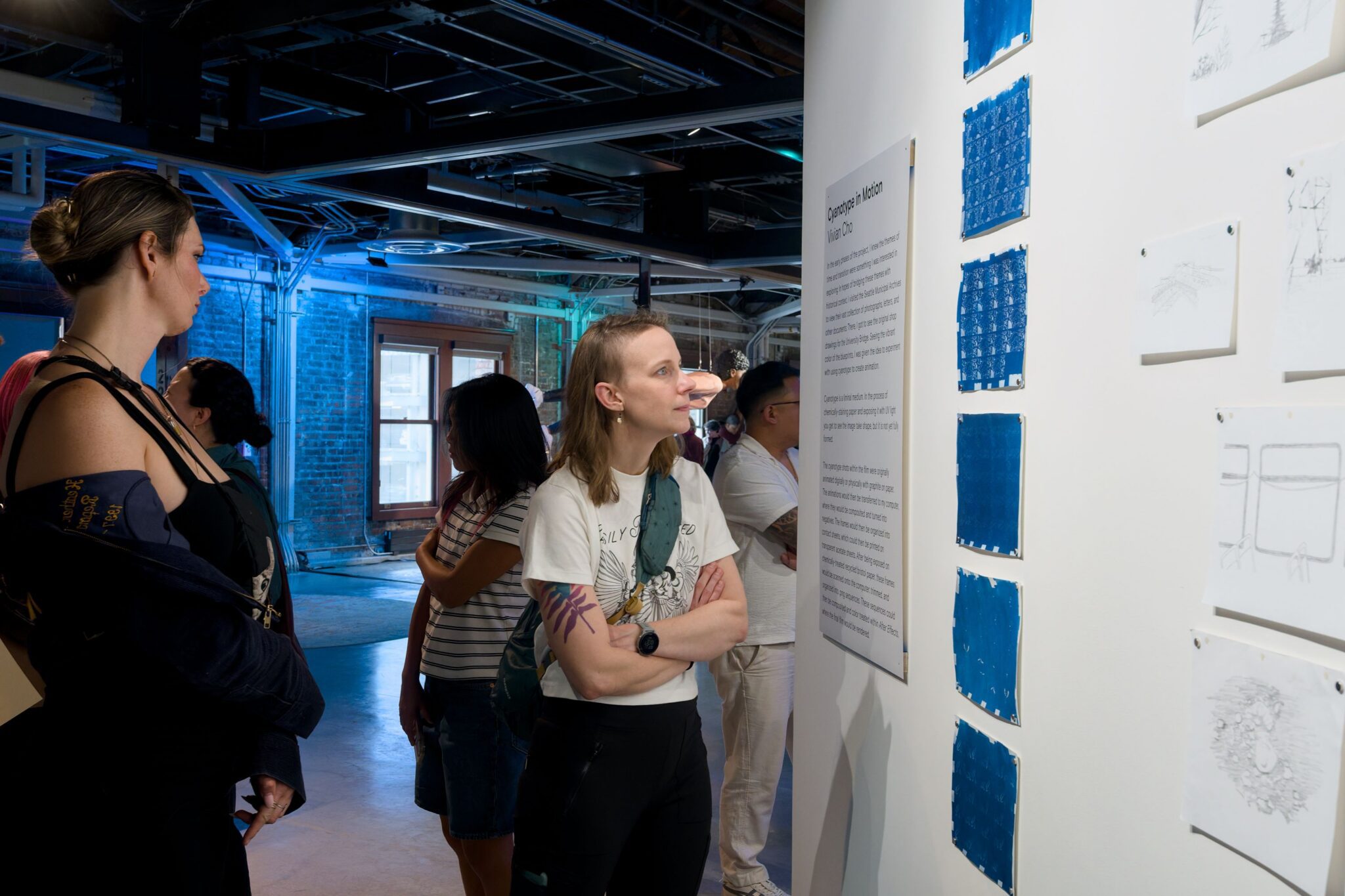 Two people reading an exhibit description poster.