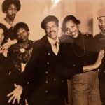 Sepia colored old photo of six Black men and women smiling and posing together
