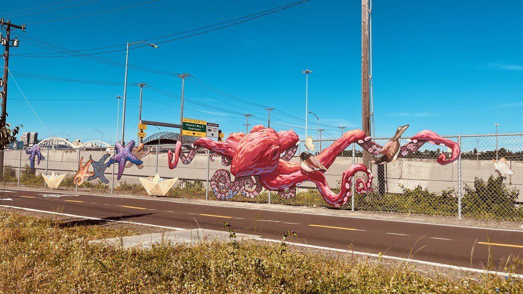 A large red octopus artwork along a chainlink fence