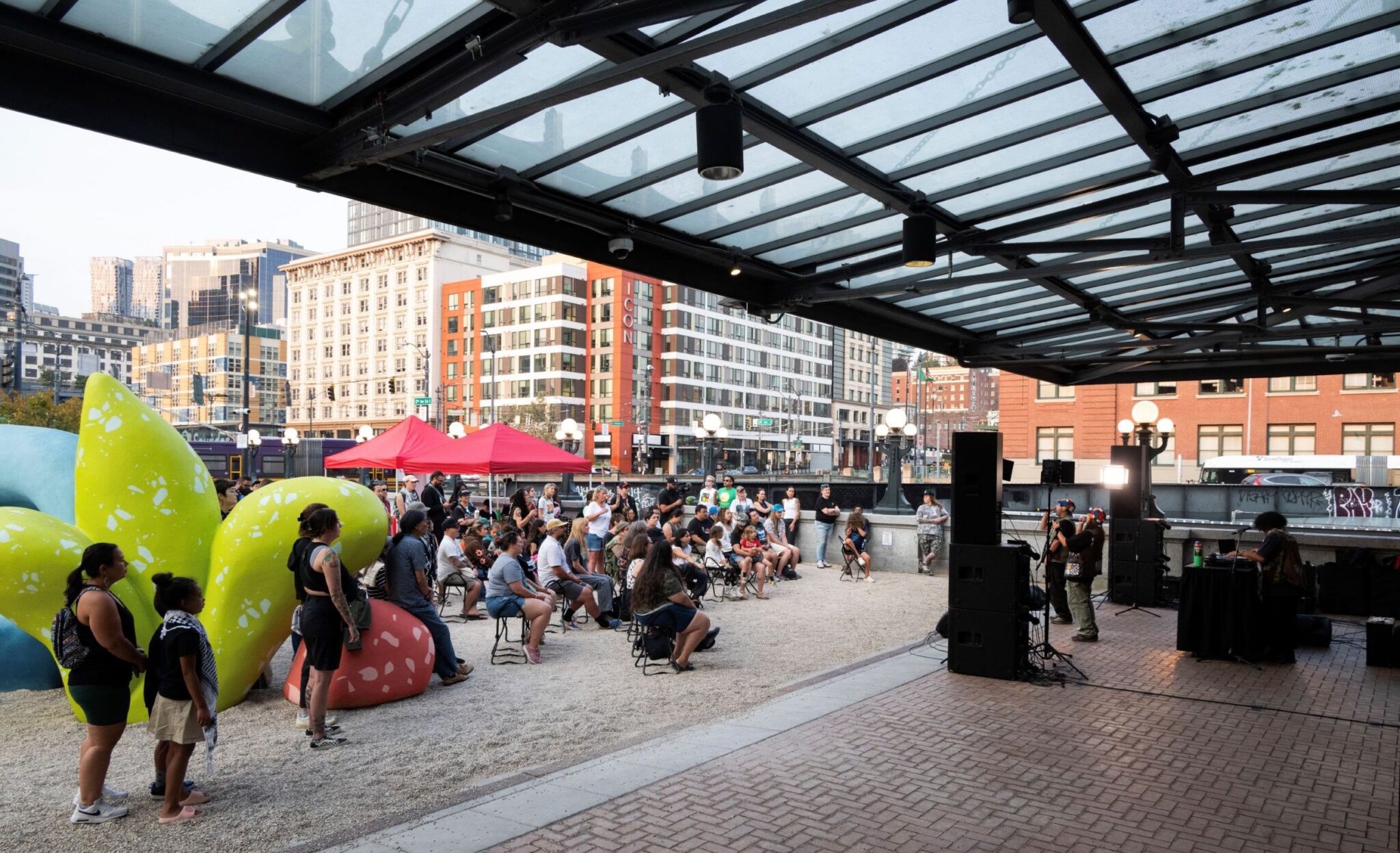 A large crowd watches a performance on the King Street Station Plaza