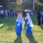 Two Somali girls dressed in the flag have an animated conversation.