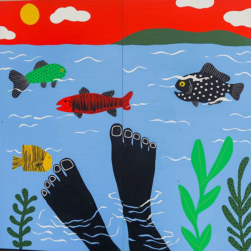 Square painted panel of a pair of feet dipped in a body of water. Fish and plants surround it.